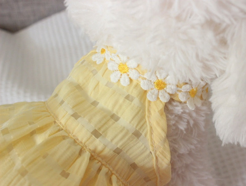 Close-up of a yellow fabric with floral embellishments on a fluffy white background