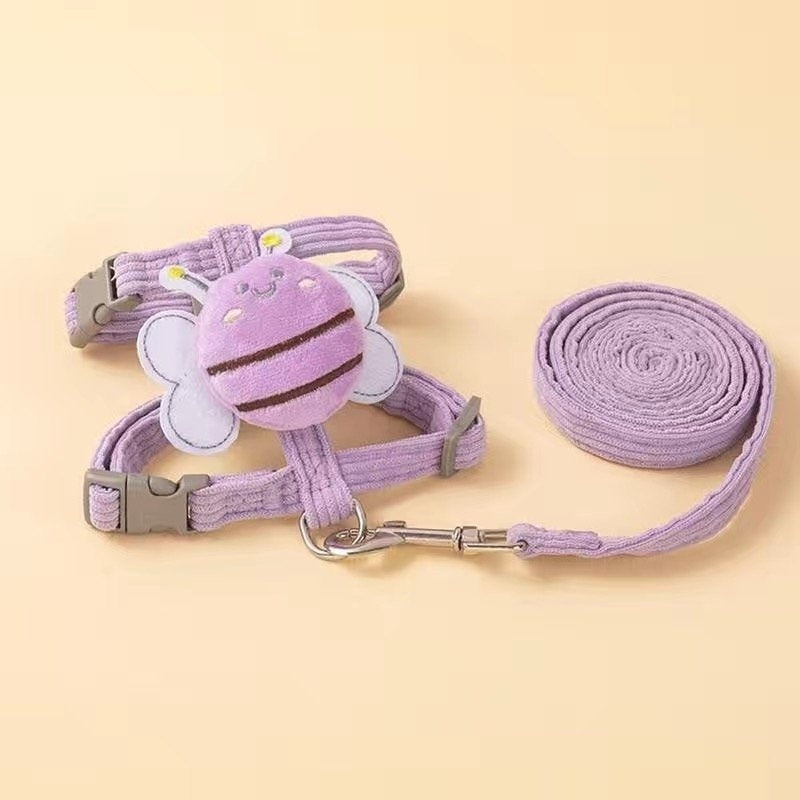 Purple pet harness and leash set with a cartoon bee design on a beige background