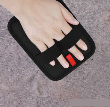 Black foot care device with a hand holding it on a gray background