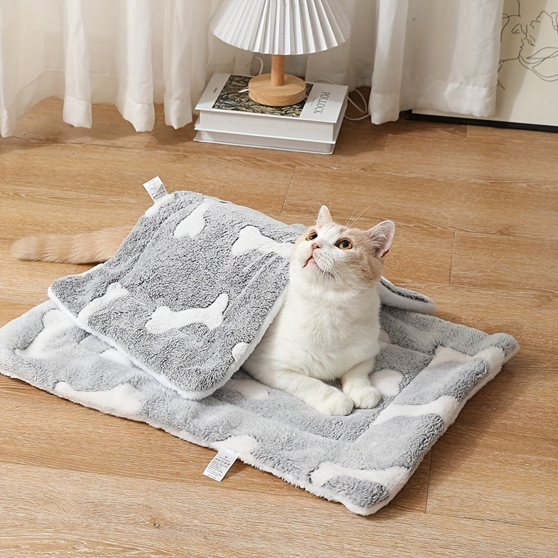 Wefulfil grey plush self-warming cat bed mat with white bone pattern and cream cat lounging on hardwood floor