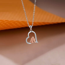 Heart-shaped pendant necklace with a rose gold heart inside on an orange and brown gradient background