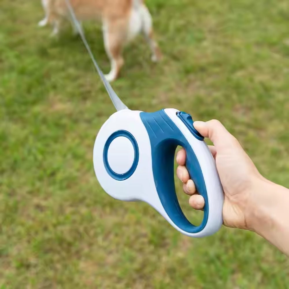 Purrfect Pet Haven Retractable Dog Leash white and blue handheld leash with ergonomic grip dog on grass