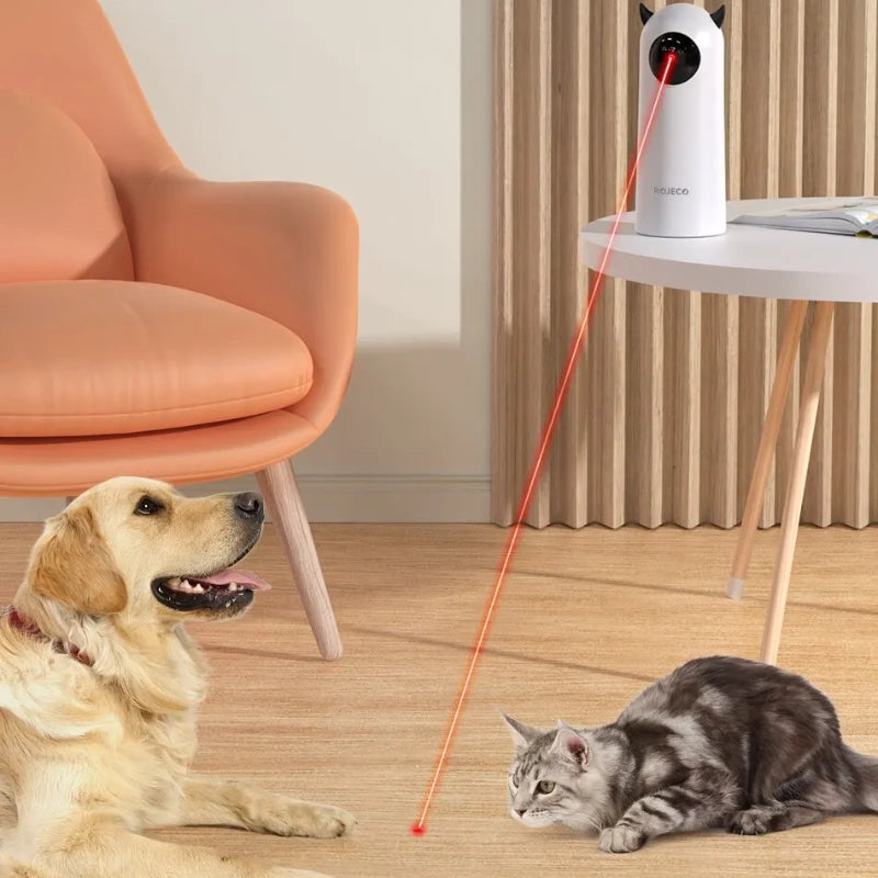 Purrfect Pet Haven Laser Cat Toy automatic projector on table with gray cat chasing red dot and golden dog watching