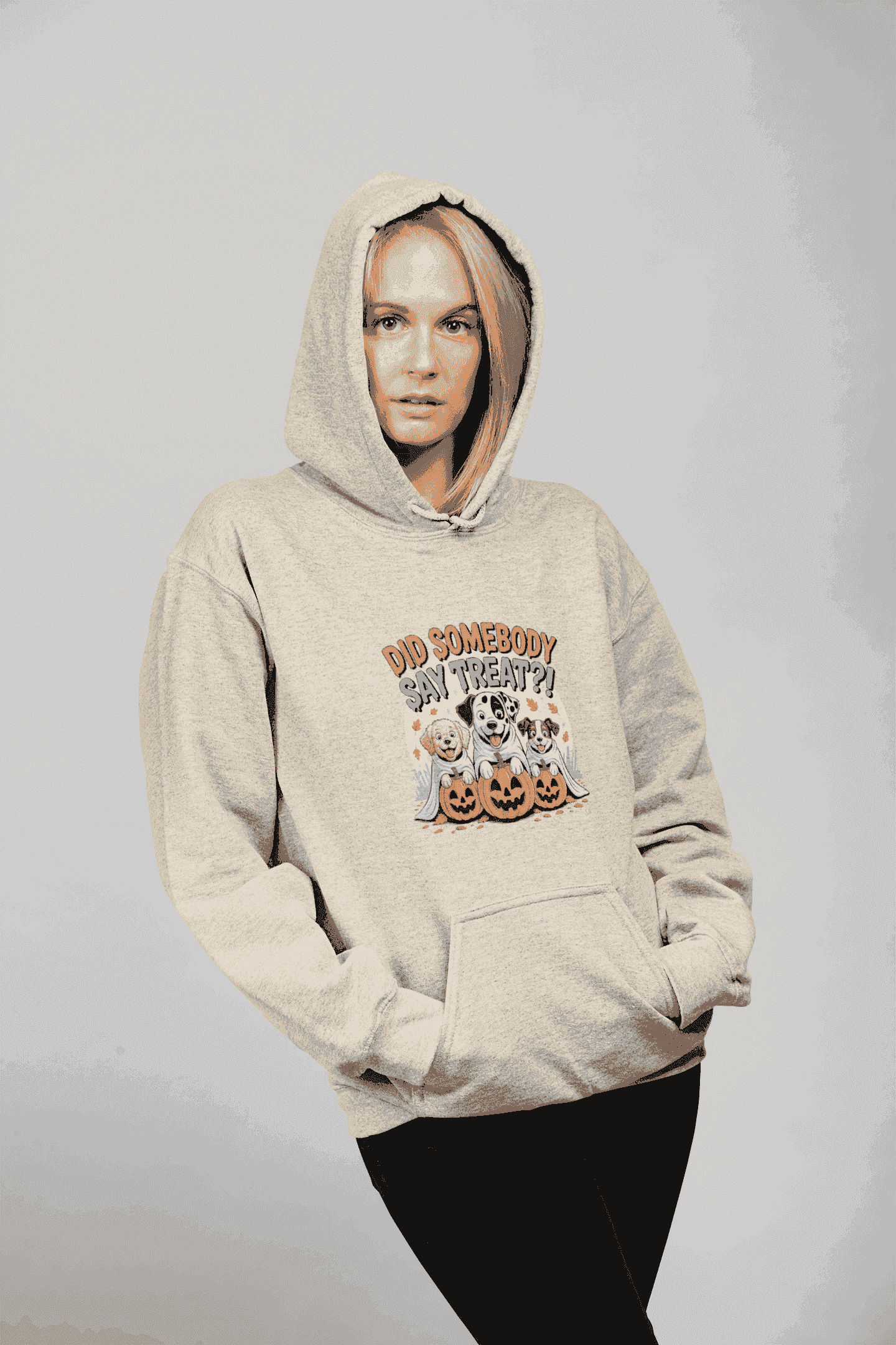 Woman modeling Printify beige hoodie featuring three dogs with pumpkins graphic titled Halloween Dog Sweatshirt