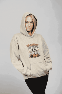 Woman modeling Printify beige hoodie featuring three dogs with pumpkins graphic titled Halloween Dog Sweatshirt