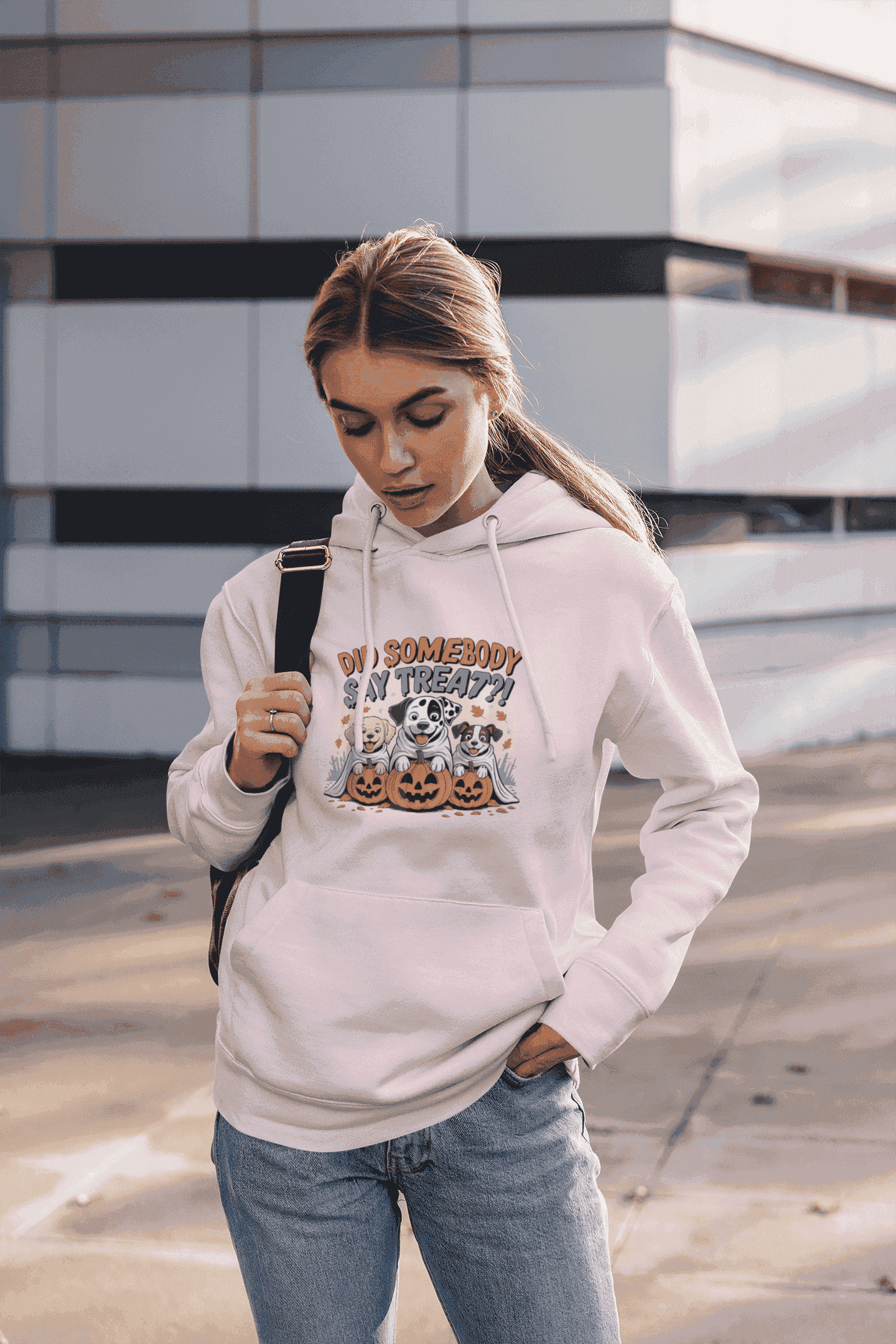 Woman wearing light pink hoodie with Halloween Dog Sweatshirt design of dogs with pumpkins casual street style