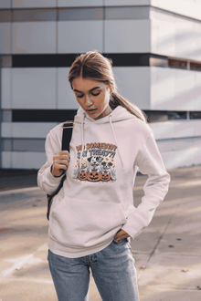 Woman wearing light pink hoodie with Halloween Dog Sweatshirt design of dogs with pumpkins casual street style