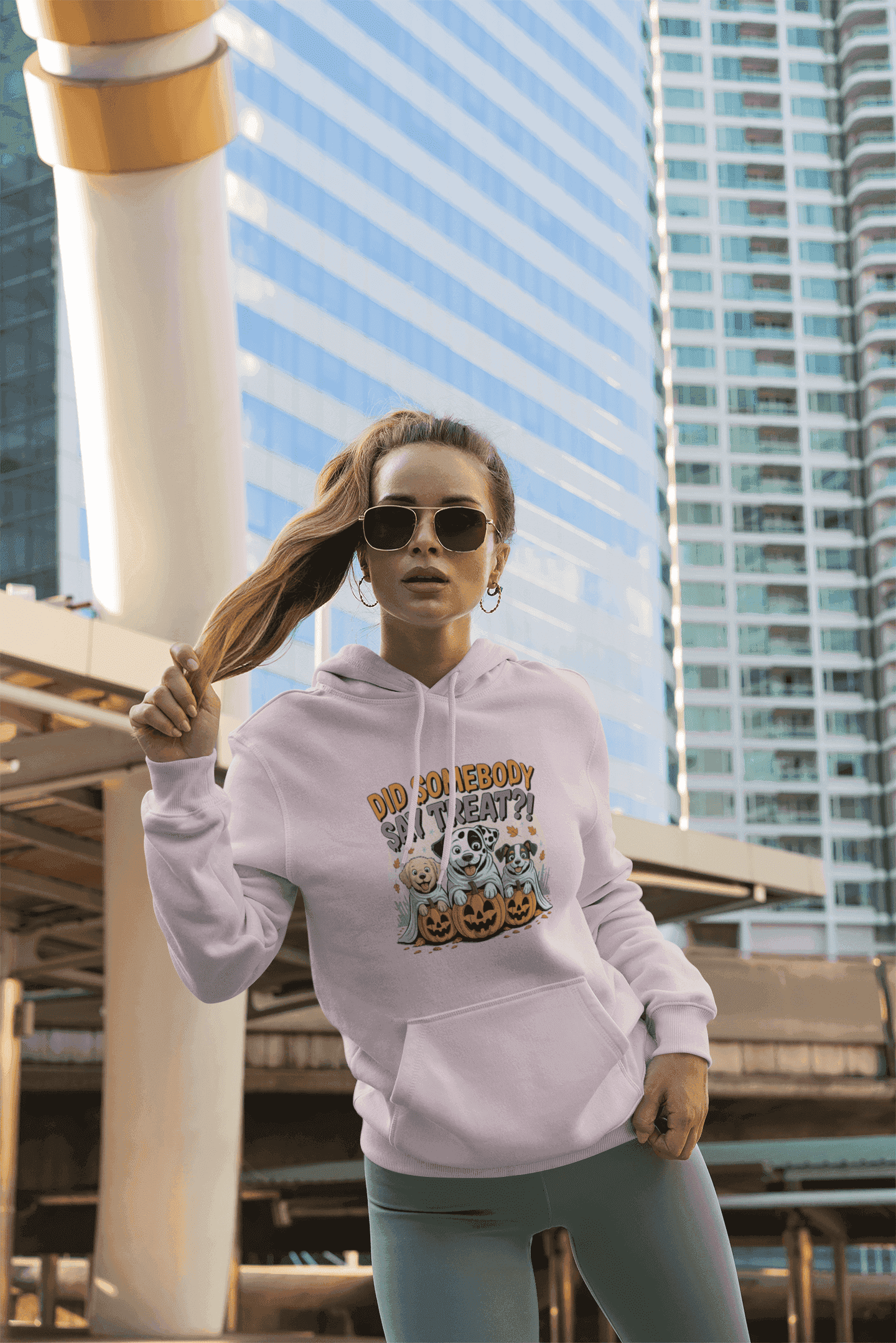 Printify hoodie with Halloween Dog Sweatshirt design worn by woman in urban setting showing dog and pumpkin art