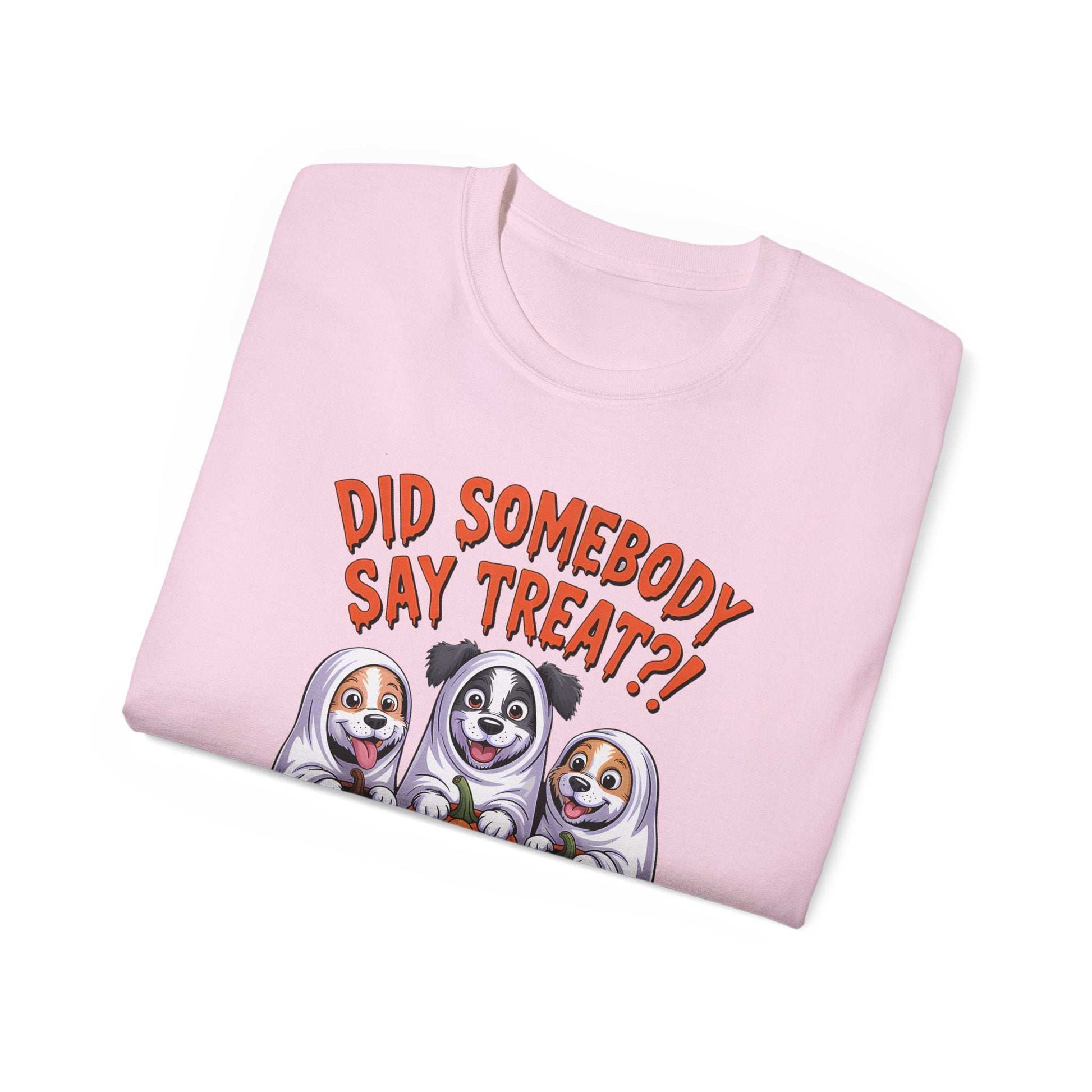 Spooky Halloween Dog Tee pink folded t shirt with three cartoon dogs in ghost costumes and treat text