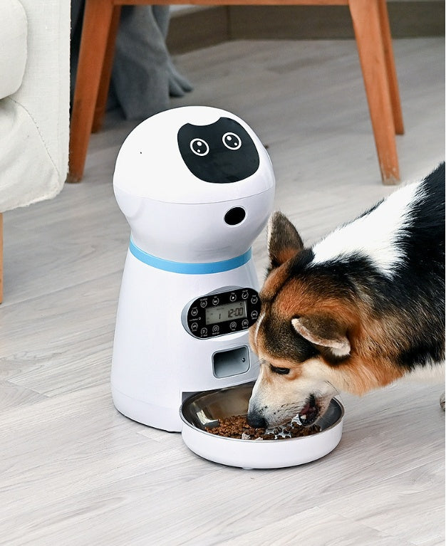 Dog eating from a bowl attached to a digital pet feeder on a wooden floor.