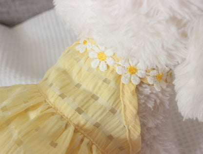 Close-up of a yellow fabric with floral embellishments on a fluffy white background