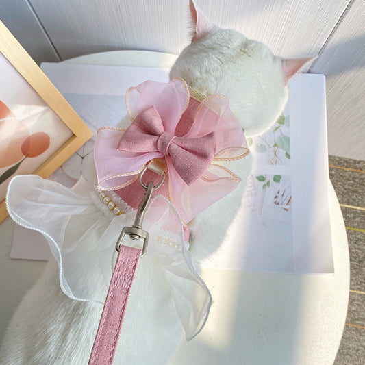 Small round white plush toy with a pink bow on a light surface.