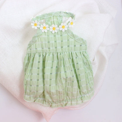 Green baby romper with floral headband on a white background
