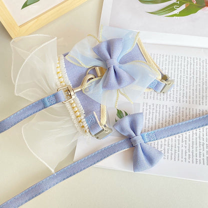 Light blue dog harness with bow tie on a white surface