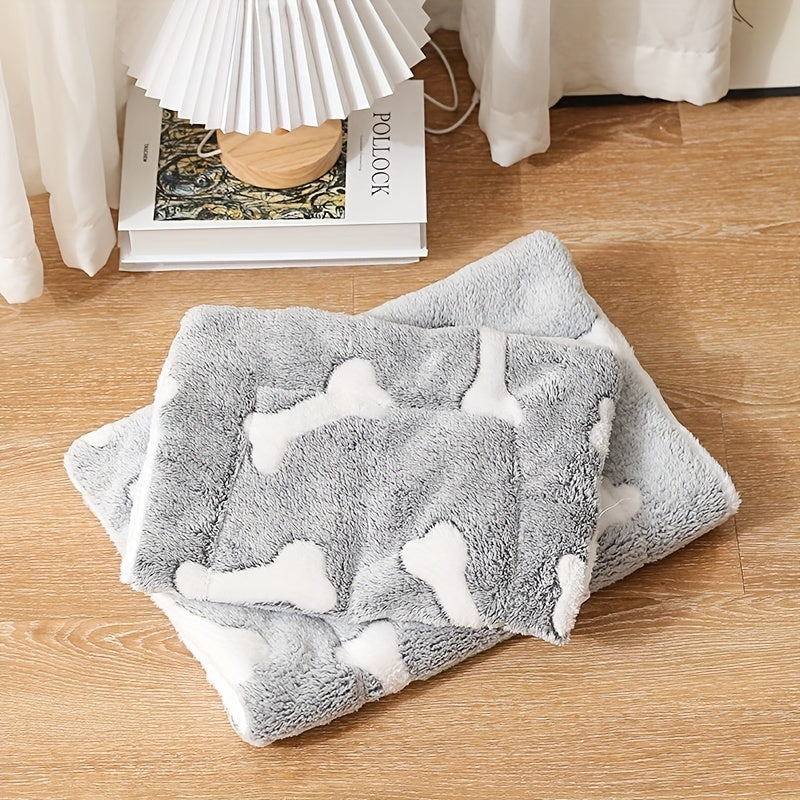 Wefulfil grey plush self-warming cat bed mat with white bone pattern folded on wooden floor near lamp