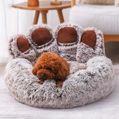 Purrfect Pet Haven paw-shaped pet bed in plush gray with brown paw pads holding a small brown poodle