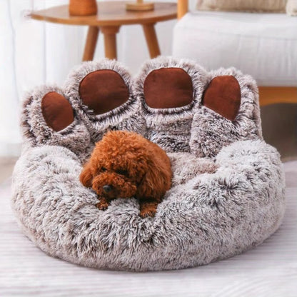Purrfect Pet Haven paw-shaped pet bed in plush gray with brown paw pads holding a small brown poodle
