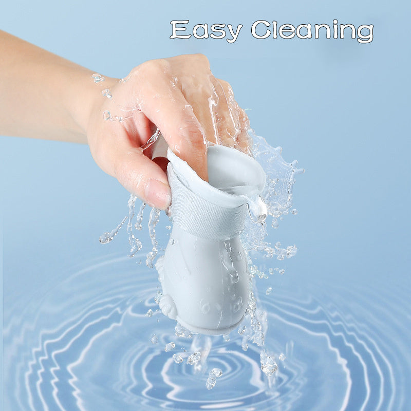 Hand rinsing a white Dog 4 Piece Rain Boots under water for easy cleaning by Wefulfil