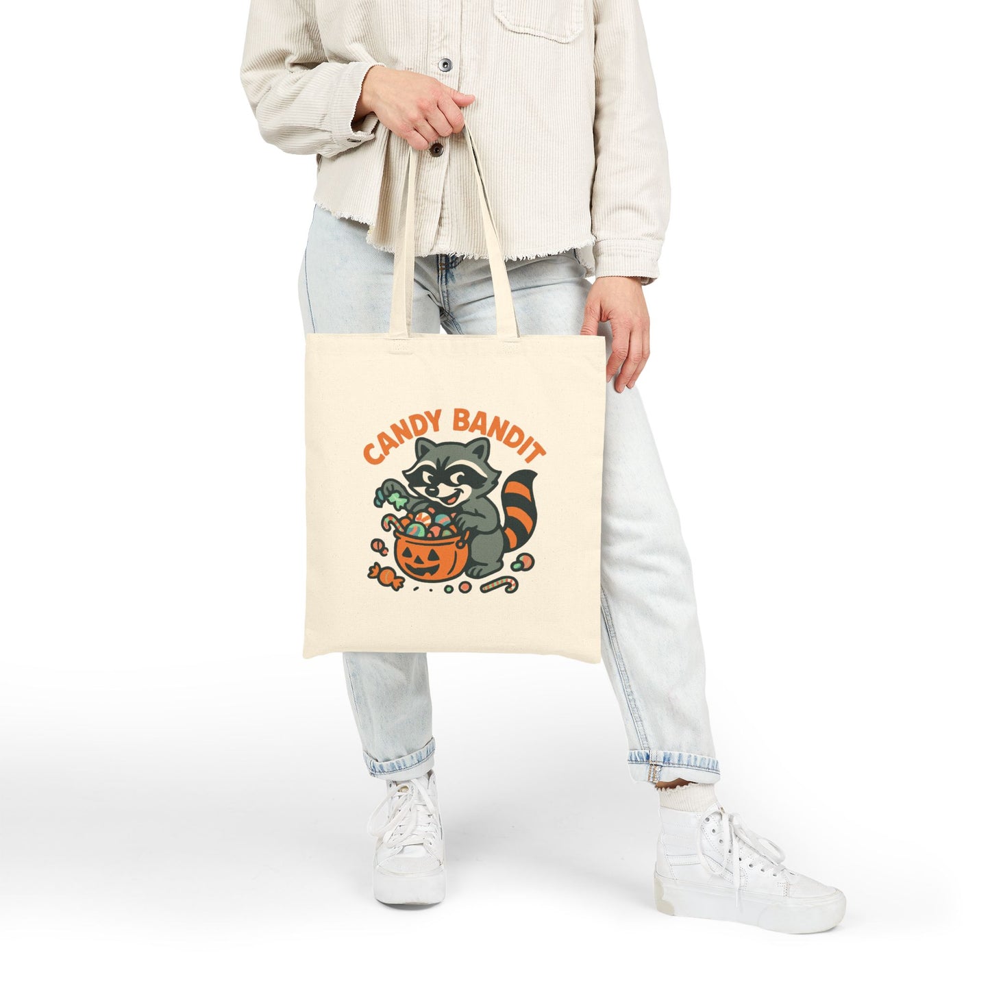 Printify Canvas Tote Bag off white with Candy Bandit raccoon Halloween candy pumpkin print held by model