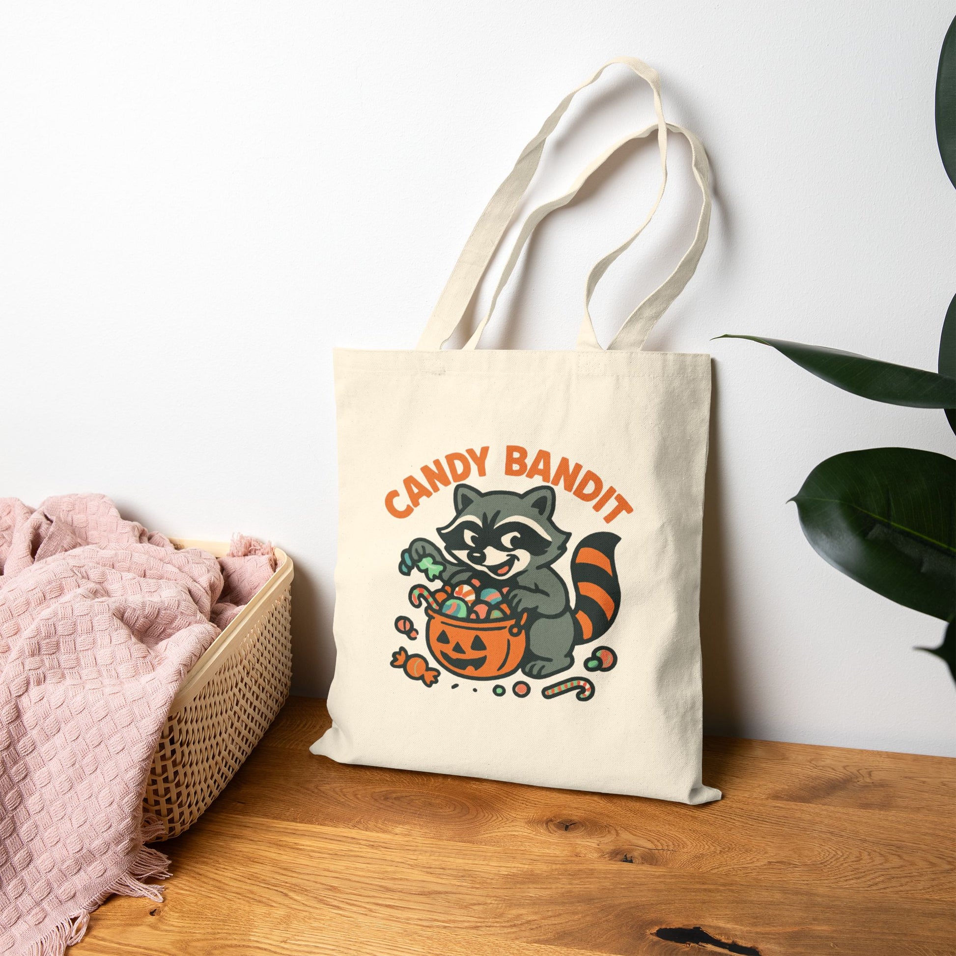 Printify Canvas Tote Bag featuring Candy Bandit raccoon with pumpkin candy bucket on natural canvas tote