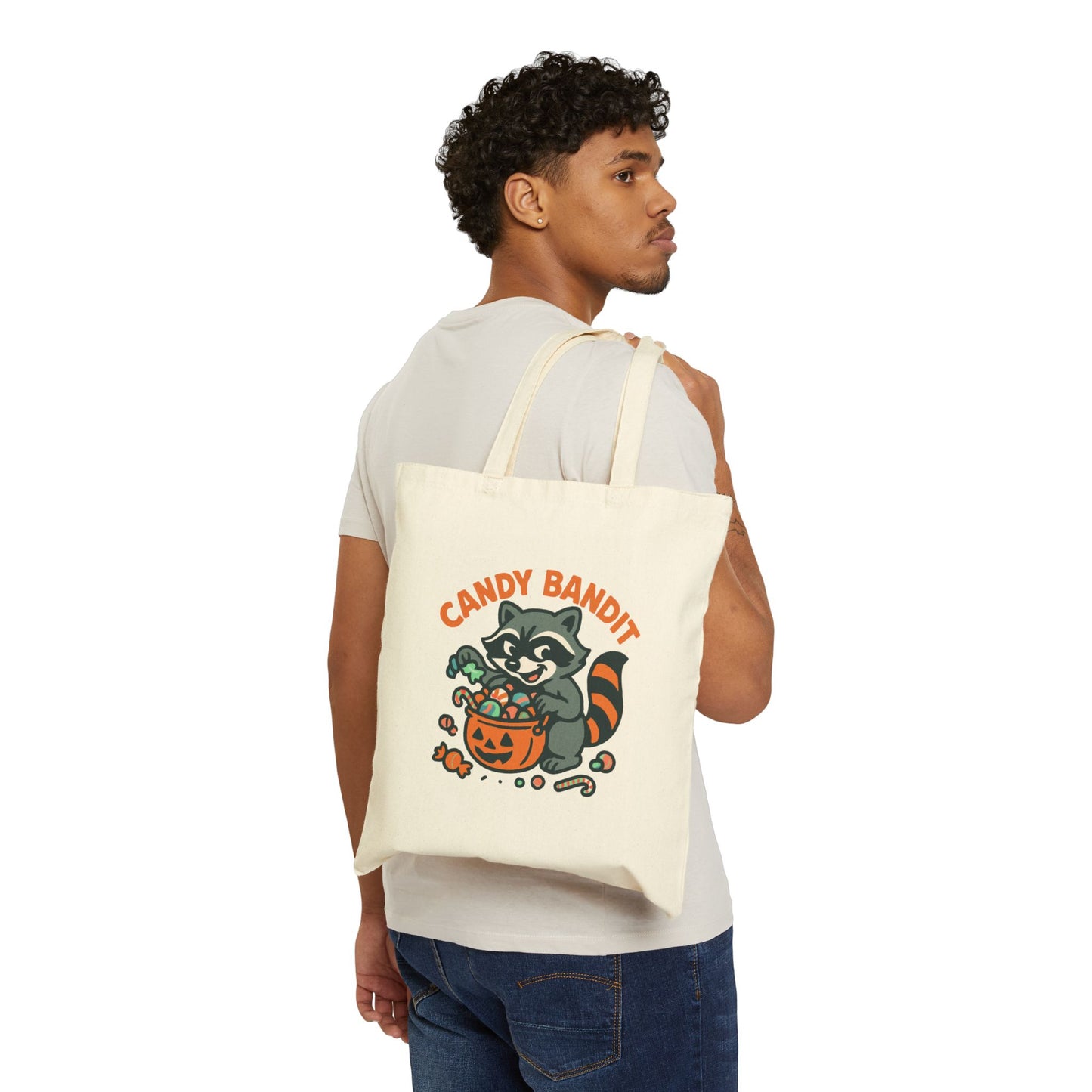 Printify Canvas Tote Bag with Candy Bandit raccoon Halloween design held over shoulder by model