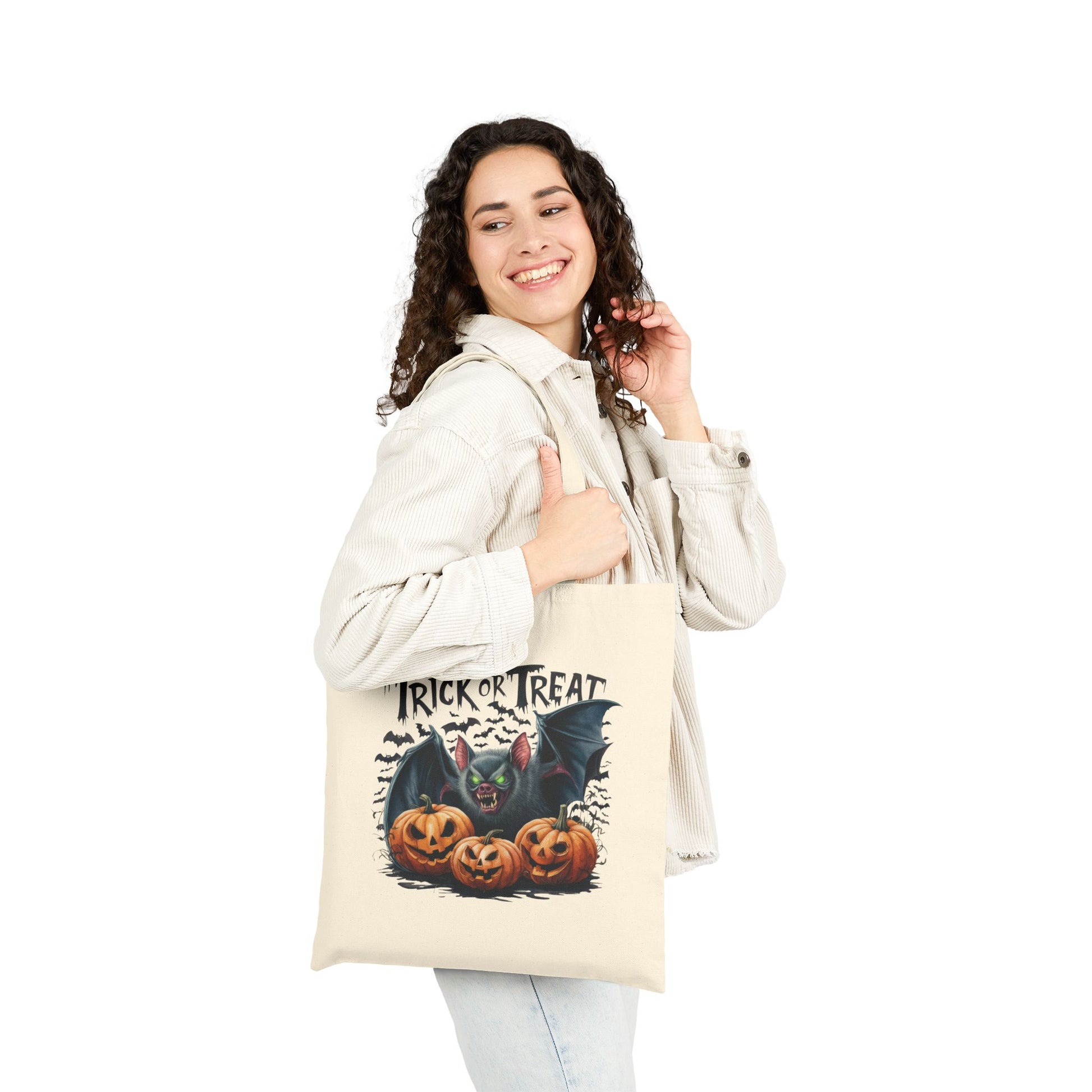 Young woman holding Canvas Tote Bag with Halloween Trick or Treat bat and carved pumpkins design