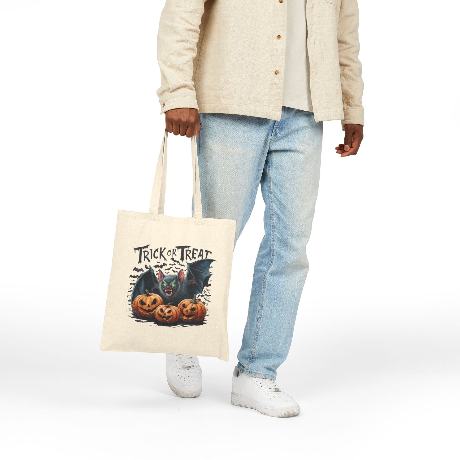 Canvas Tote Bag with Halloween Trick or Treat bat and carved pumpkin print held by person