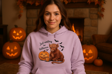 Woman by Fireplace in Highland Cow Halloween Hoodie