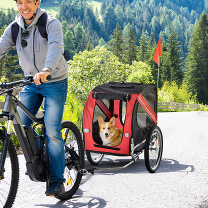 Man riding bike with Wefulfil Large Wheel Dog Bike Trailer carrying a happy dog on a scenic path