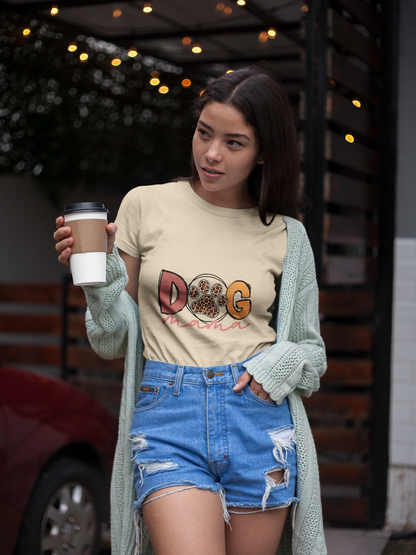 Young woman wearing a Dog Mama Tee cream shirt with knitted cardigan and ripped denim shorts holding coffee outdoors
