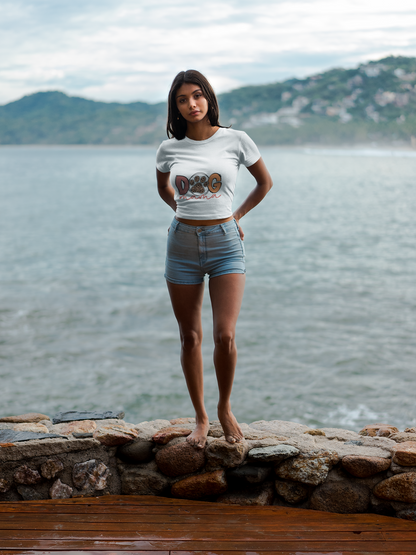 Woman standing barefoot by the sea wearing a fitted Printify Dog Mama Tee and denim shorts