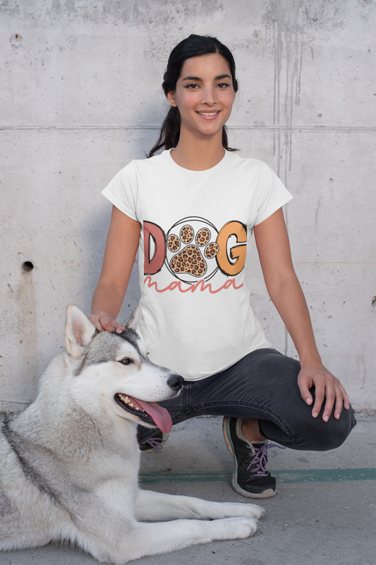 Woman kneeling with husky pet wearing white Dog Mama Tee featuring paw print design outdoors