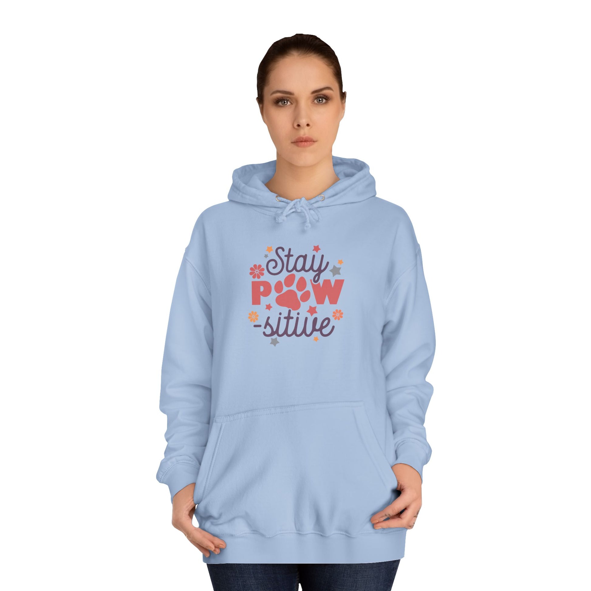Female model wearing light blue Stay Pawsitive Unisex Hoodie with paw graphic drawstring hood and kangaroo pocket by Printify