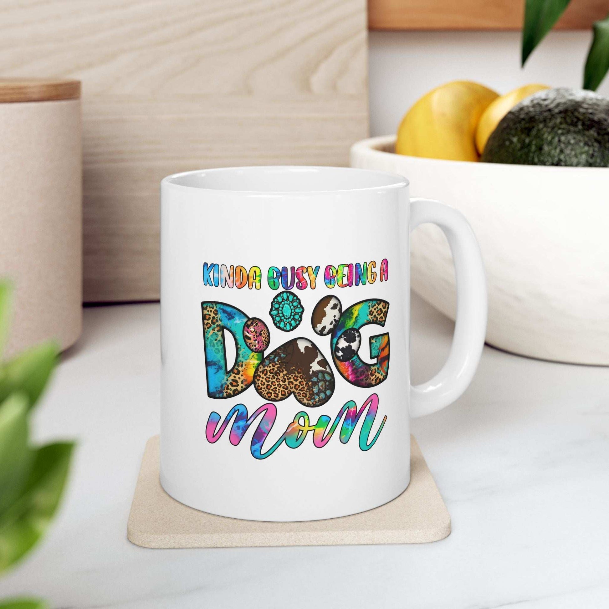 White ceramic mug with colorful Kinda Busy Being a Dog Mom design and paw print Pet Owner Coffee Cup