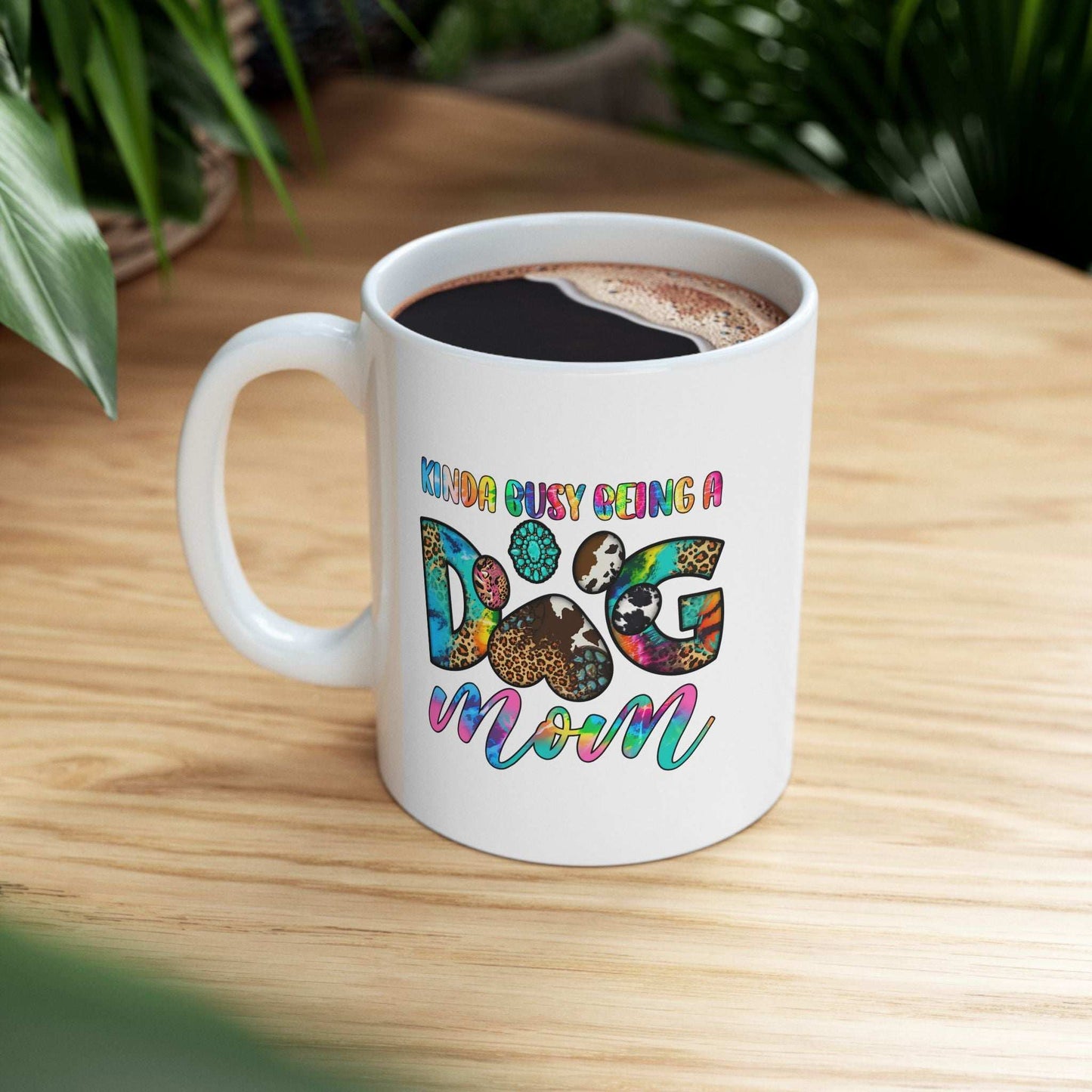 White ceramic mug with colorful dog mom design filled with coffee on a wooden table Pet Owner Coffee Cup