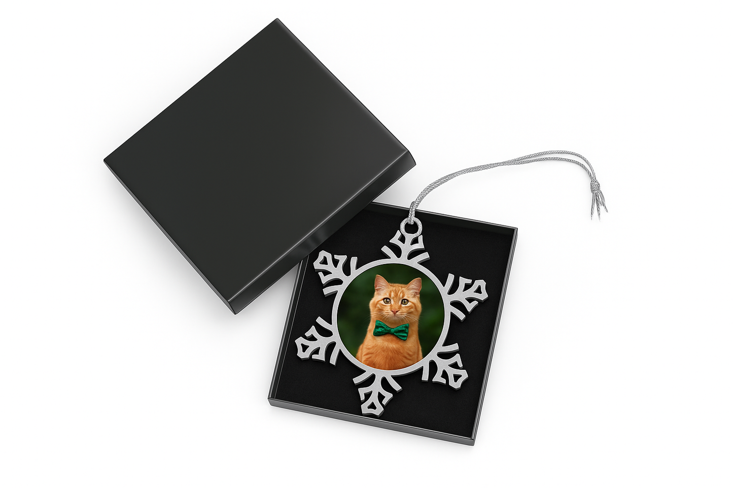 Snowflake Pet Ornament featuring orange cat in green bow tie inside black gift box on white background