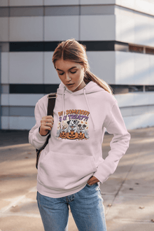 Woman wearing light pink hoodie with Halloween Dog Sweatshirt design of dogs with pumpkins casual street style