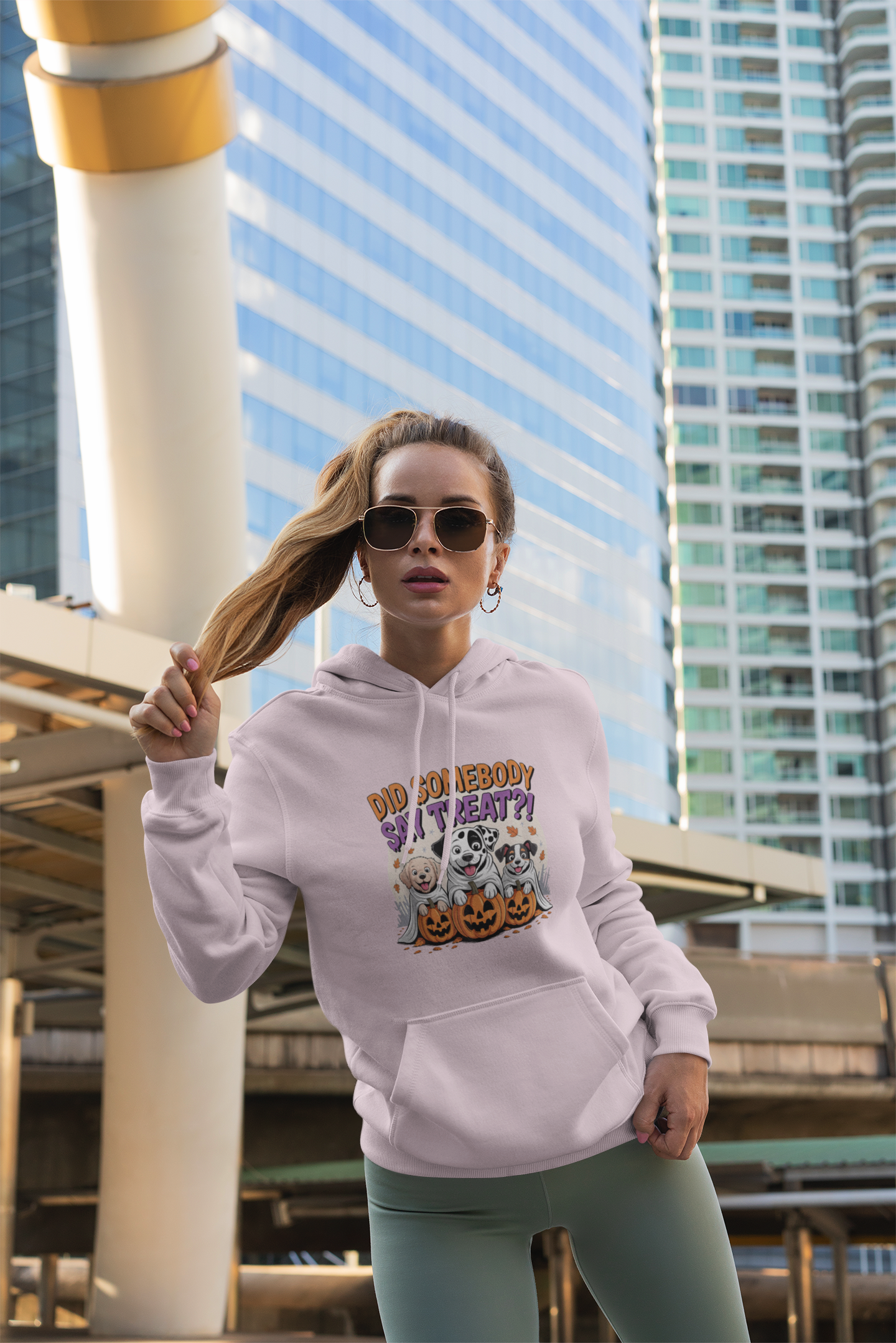 Printify hoodie with Halloween Dog Sweatshirt design worn by woman in urban setting showing dog and pumpkin art