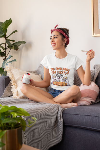 Smiling woman on sofa wearing Printify Spooky Halloween Dog Tee white shirt with three dogs and treats graphic holding dessert