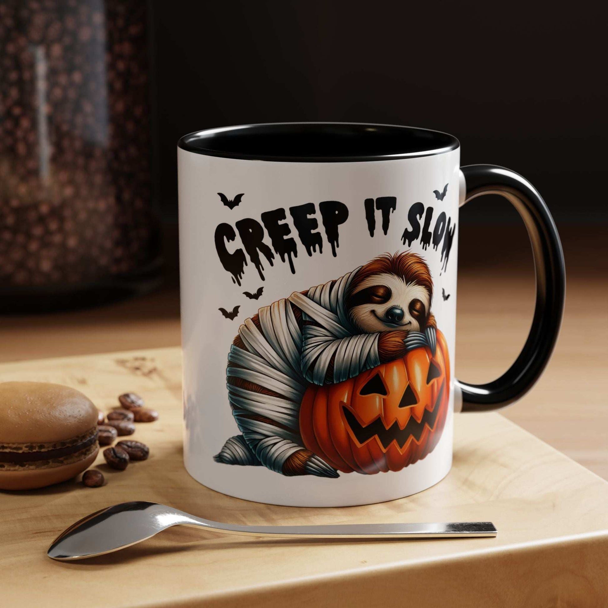Halloween Sloth Coffee Mug white ceramic with black handle showing mummy sloth hugging jack o lantern and Creep It Slow text