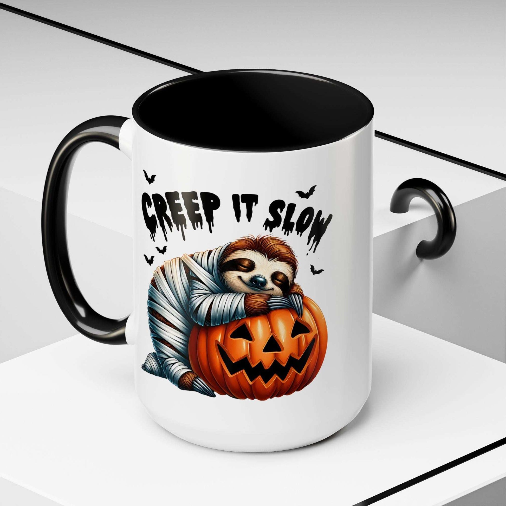 Halloween Sloth Coffee Mug white with black handle featuring a mummy sloth hugging a carved pumpkin and Creep It Slow text