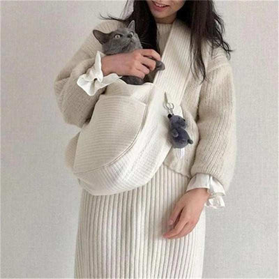 Wefulfil Cozy Pet Sling Carrier in white holding a gray cat with a plush keychain attached