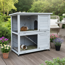 White rabbit hutch with guinea pigs on patio deck