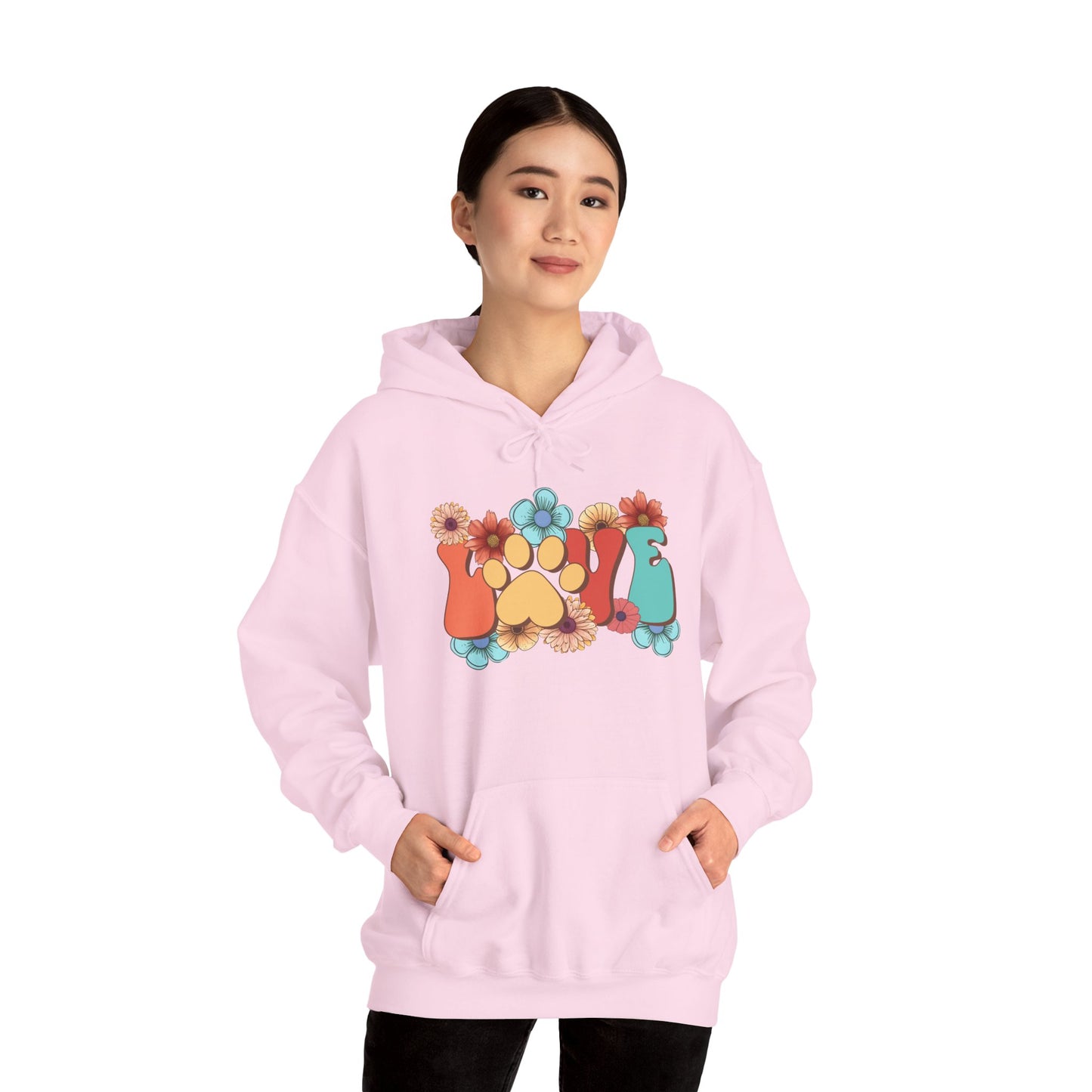 Printify light pink Animal Lover Hoodie worn by woman featuring colorful paw print and floral graphic