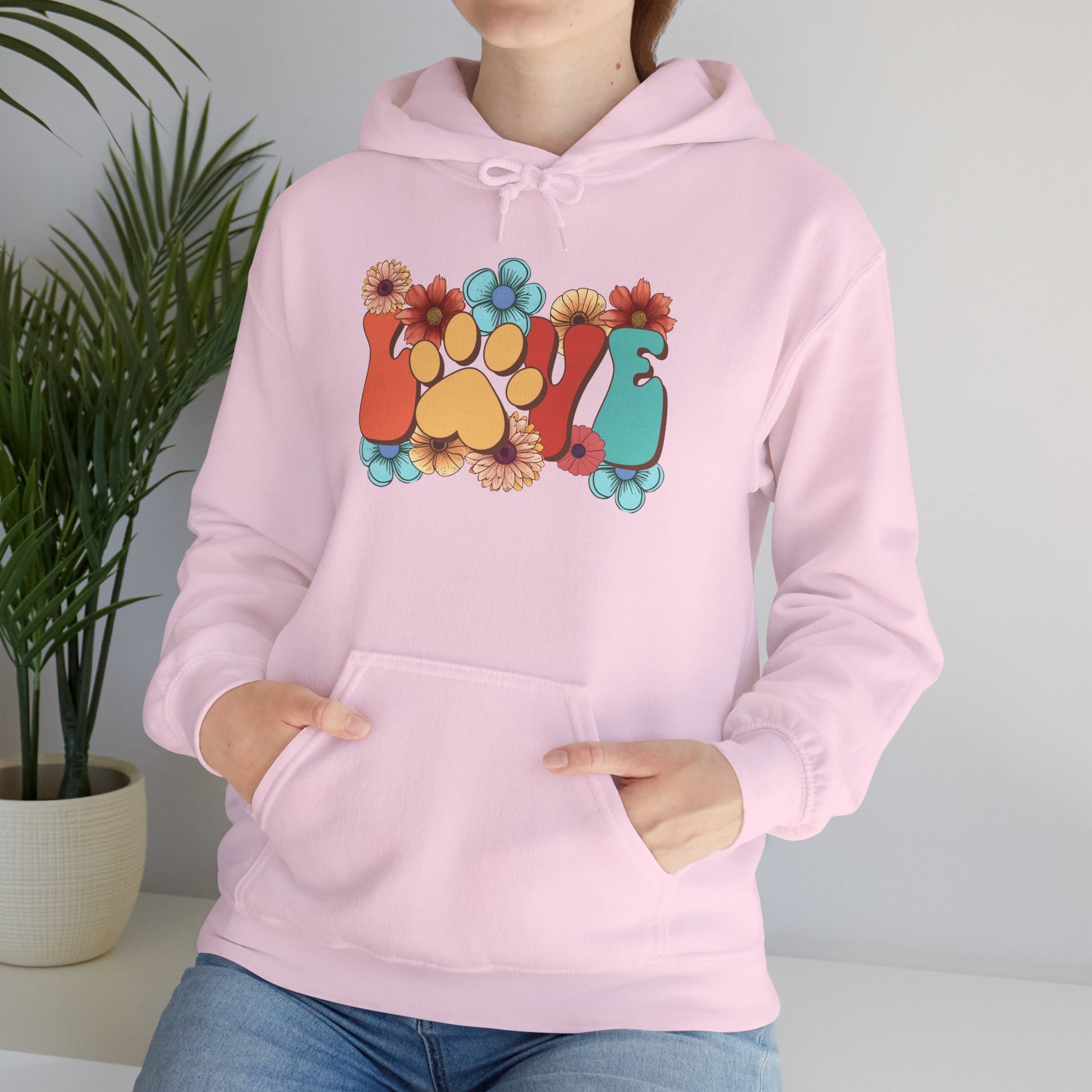 Printify pink hoodie with floral paw print LOVE graphic worn by model Animal Lover Hoodie